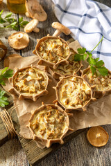 Rustic mushroom tartlets on wooden cutting board perfect for  appetizers.