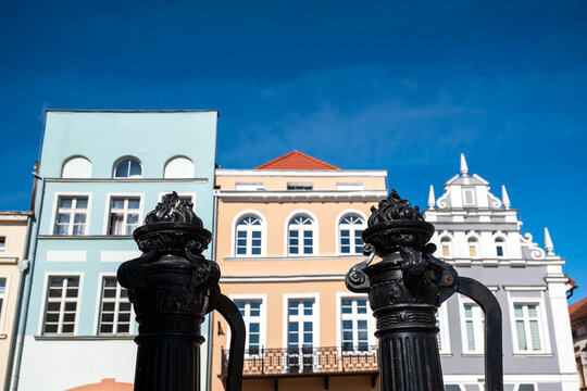 Gniew, Poland view on historic cast iron hand operated water pumps with tenement houses in the background