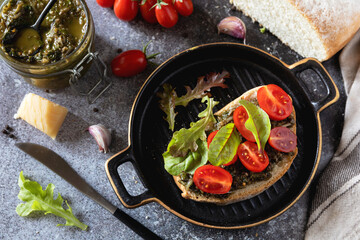 Fresh mediterranean bruschetta with cherry tomatoes and basil on grilled bread.