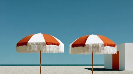 Two vibrant beach umbrellas with red and white stripes stand on sandy shore under clear blue sky, creating a serene atmosphere perfect for relaxation and summer enjoyment by the ocean