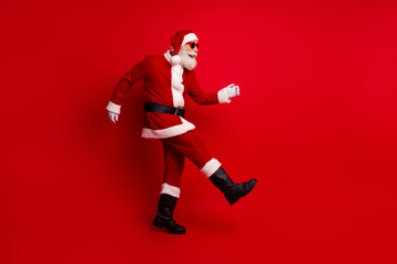 Santa Claus walking confidently in festive attire showcasing joy of holiday spirit and Christmas celebration against a red background