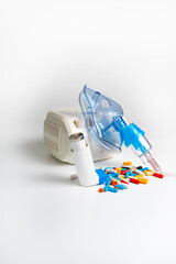 Medical inhaler, nebulizer, nebular, pills, capsules. Asthma breathing treatment. Bronchitis, asthmatic health equipment. Electric nebulizer for cough treatment on white background.