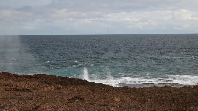 rugged landscape of the rocky cliffs at Quobba Blow Holes, Macleod, Western Australia, along the coastline of the indian Ocean in West Australia with waves crushing ashore.