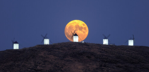 Full Moon Rising Behind Traditional Windmills at Twilight