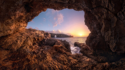 Sunset View from a Sea Cave Overlooking Natural Rock Arch in Menorca