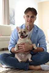 Obraz premium Man with his cute French bulldog at home
