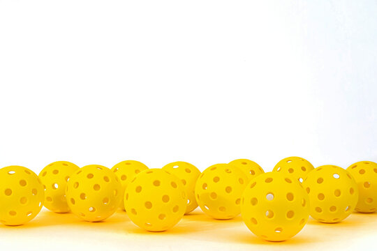 Yellow Pickleballs on a white background.  Lots of room for text.