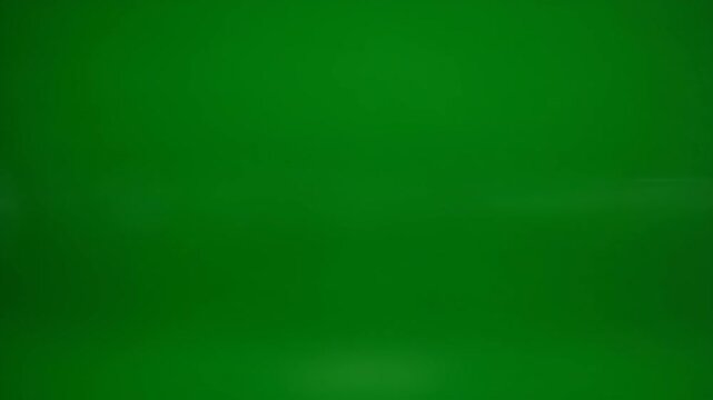 Intense white lens flares streaking horizontally across green screen. Chromakey background for vfx compositing and special effects integration. Dynamic lighting action footage for film production.