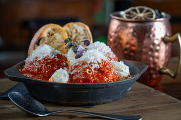 Meatballs topped with cheese, a side of crostini and a Moscow Mule.