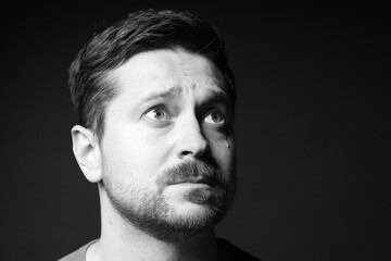 Obraz premium Sad man crying on dark background, space for text. Black and white effect