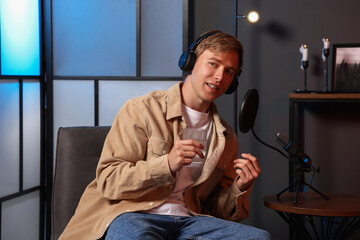 Podcast host in headphones recording talk show indoors, view from camera