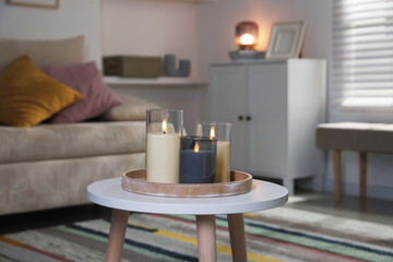 Decorative LED candles on white table at home