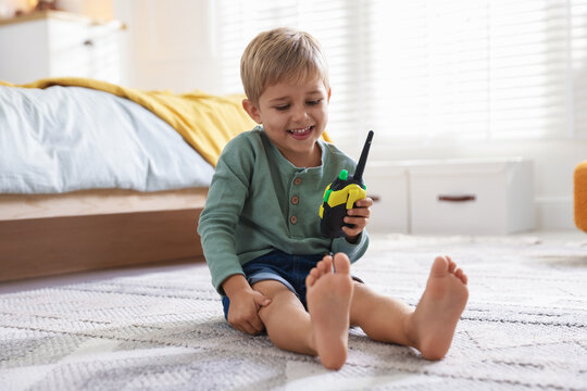 Little boy playing with walkie talkie toy at home