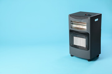 Fototapeta premium Electric heater on light blue background. Space for text
