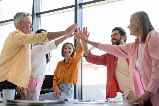 Diverse business team celebrating success high five