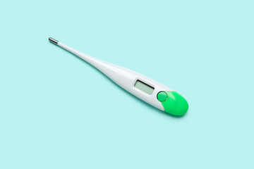 Electronic thermometer on turquoise background