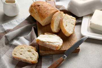 Sliced bread with butter and jug of cream on grey grunge background