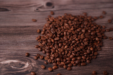 close-up of a rustic wooden surface adorned with a generous heap of aromatic brown coffee beans, emphasizing rich textures and warm earthy tones in a cozy atmosphere, essence, tradition, calm