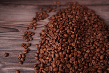 abundant pile of richly roasted coffee beans spilling across a rustic wooden surface highlighting texture and aroma, stylized, presentation, artful, spark, brownish, food, grains, hardwood, depth