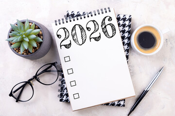 New year goals 2026 on desk. 2026 resolutions list with notebook, plant on table. Resolutions, plan, goals, action, checklist, idea concept. New Year 2026 resolutions, copy space