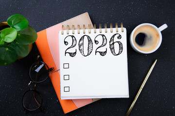 New year goals 2026 on desk. 2026 resolutions list with notebook, plant on black table. Resolutions, plan, goals, action, checklist, idea concept. New Year 2026 resolutions, copy space