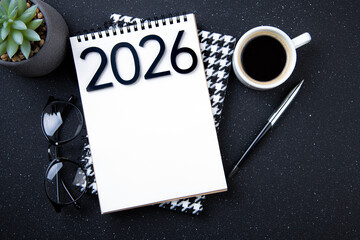 New year goals 2026 on desk. 2026 resolutions list with notebook, plant on black table. Resolutions, plan, goals, action, checklist, idea concept. New Year 2026 resolutions, copy space