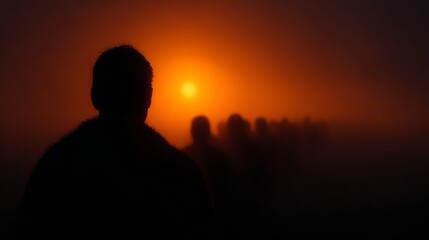 Fototapeta premium Silhouetted crowd walking into orange haze at sunset