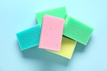 Colorful cleaning sponges on blue background