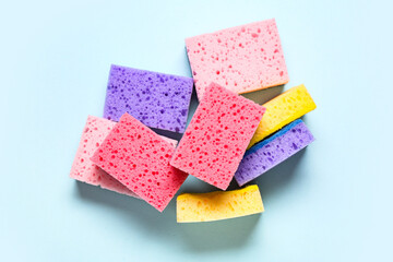 Colorful cleaning sponges on blue background
