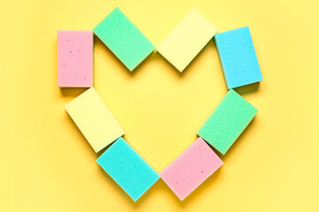 Fototapeta premium Heart made of colorful cleaning sponges on yellow background