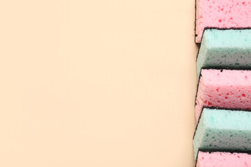 Row of cleaning sponges on beige background