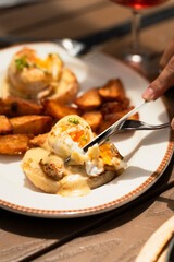 Classic American brunch spread featuring fluffy buttermilk pancakes with maple syrup, crispy bacon strips and perfectly scrambled eggs, served on rustic wooden table with fresh orange juice and coffee