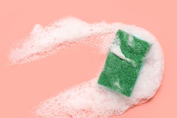 Cleaning sponge with foam on pink background