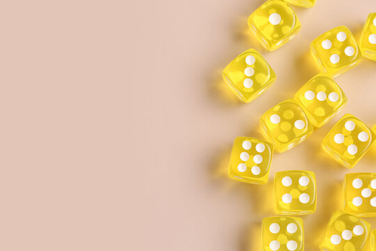 Yellow game dices on beige background