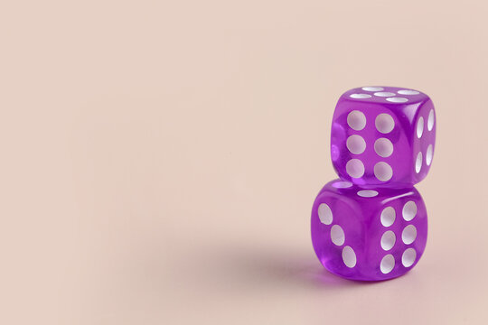Purple game dices on beige background