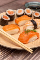  Smoked salmon uramaki with cucumber and dill, topped with thin strips of salmon on porcelain