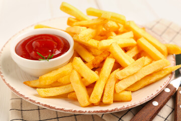Plate with tasty french fries and bowl of ketchup on light background