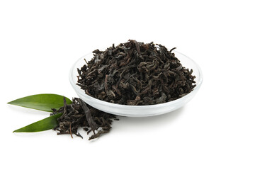 Bowl of dry black tea leaves on white background