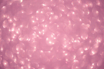 Defocused lights from pink glitter as a background.