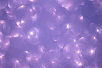 Defocused lights from purple glitter as a background.
