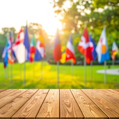 Wooden table foreground, blurry flags and greenery background, sunny day