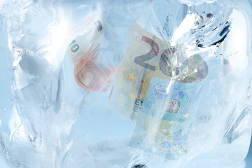 Euro bills in ice, closeup. Frozen money