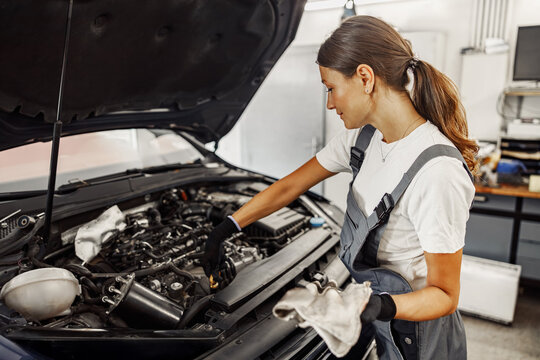 A skilled female mechanic inspects a complex engine, demonstrating her expertise in automotive repair and maintenance