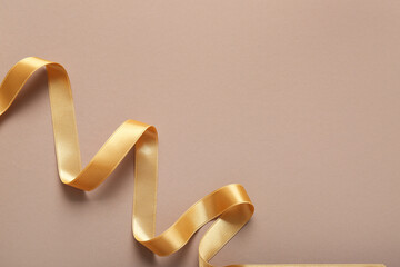 Golden satin ribbon on brown background