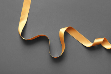 Golden satin ribbon on grey background