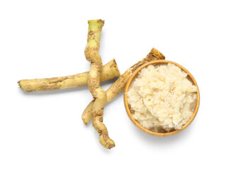 Wooden bowl of horseradish sauce with root on white background