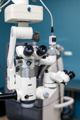 Advanced ophthalmic microscope with dual eyepieces and adjustable components, set against a modern clinical backdrop, showcasing precision in vision examination technology