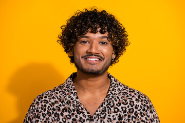 Obraz premium Happy young man on a yellow background wearing a leopard print shirt, smiling confidently and showcasing trendy fashion