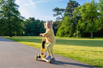 Scooter and kid. Toddler outdoor riding. Fun yellow play childhood freedom.