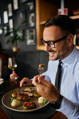 Happy businessman enjoying in meal in restaurant.